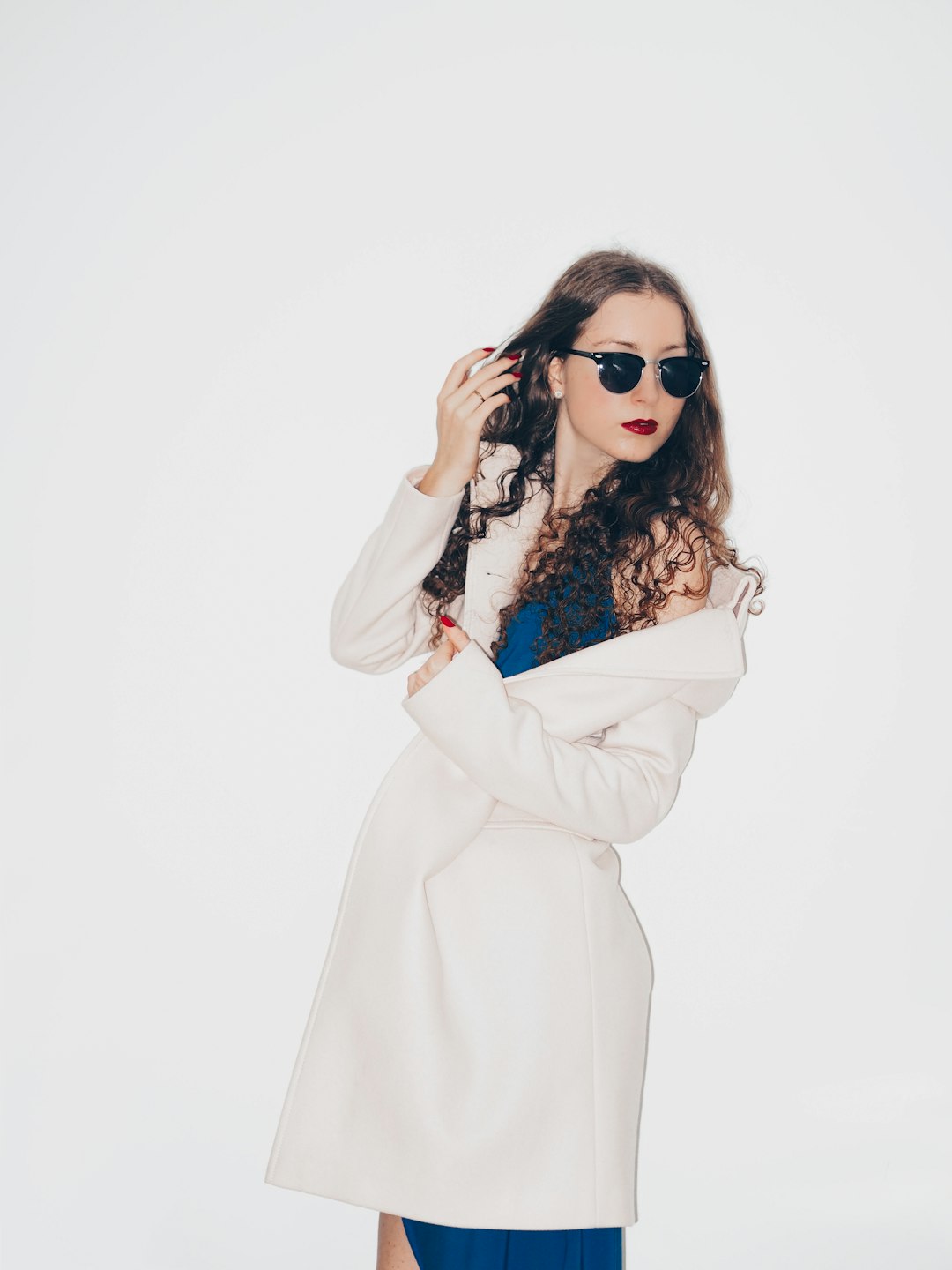 woman in white coat wearing black sunglasses