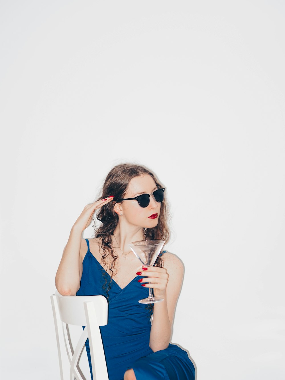 woman in blue sleeveless dress wearing black sunglasses