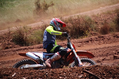Rider navigating a rugged dirt trail with dust flying behind.