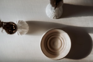 An artistic still life of aged bronze objects resting on textured fabric under soft light