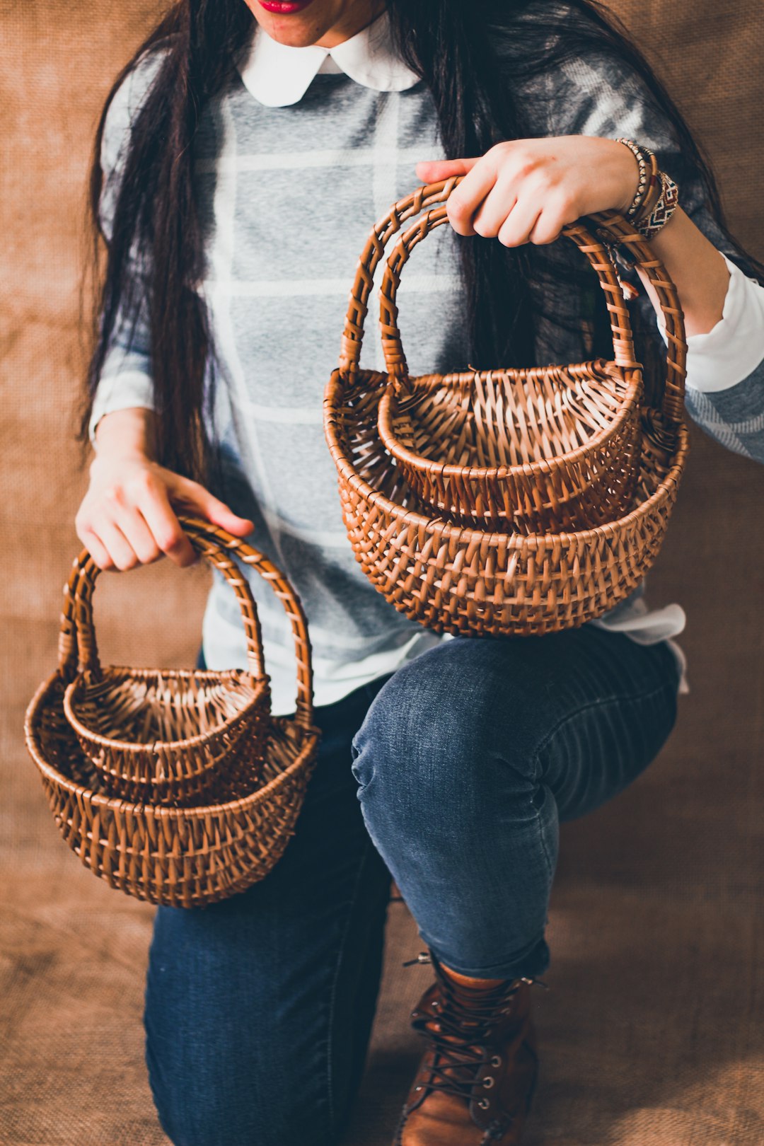 woman in blue denim jeans holding brown woven basket