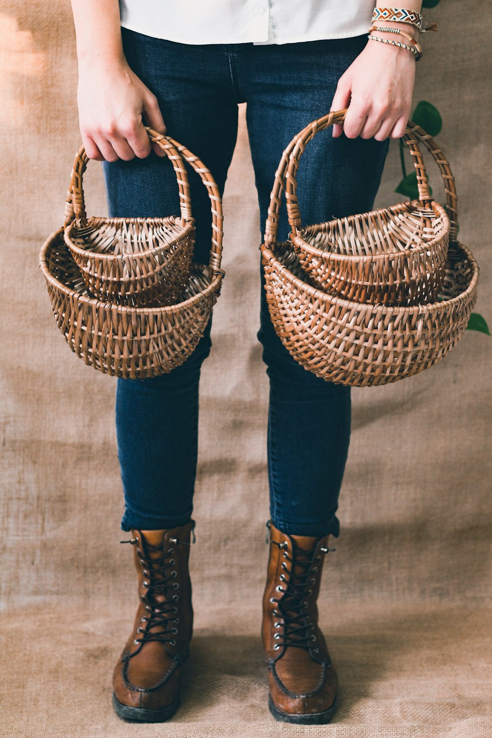 person in blue denim jeans holding brown woven basket