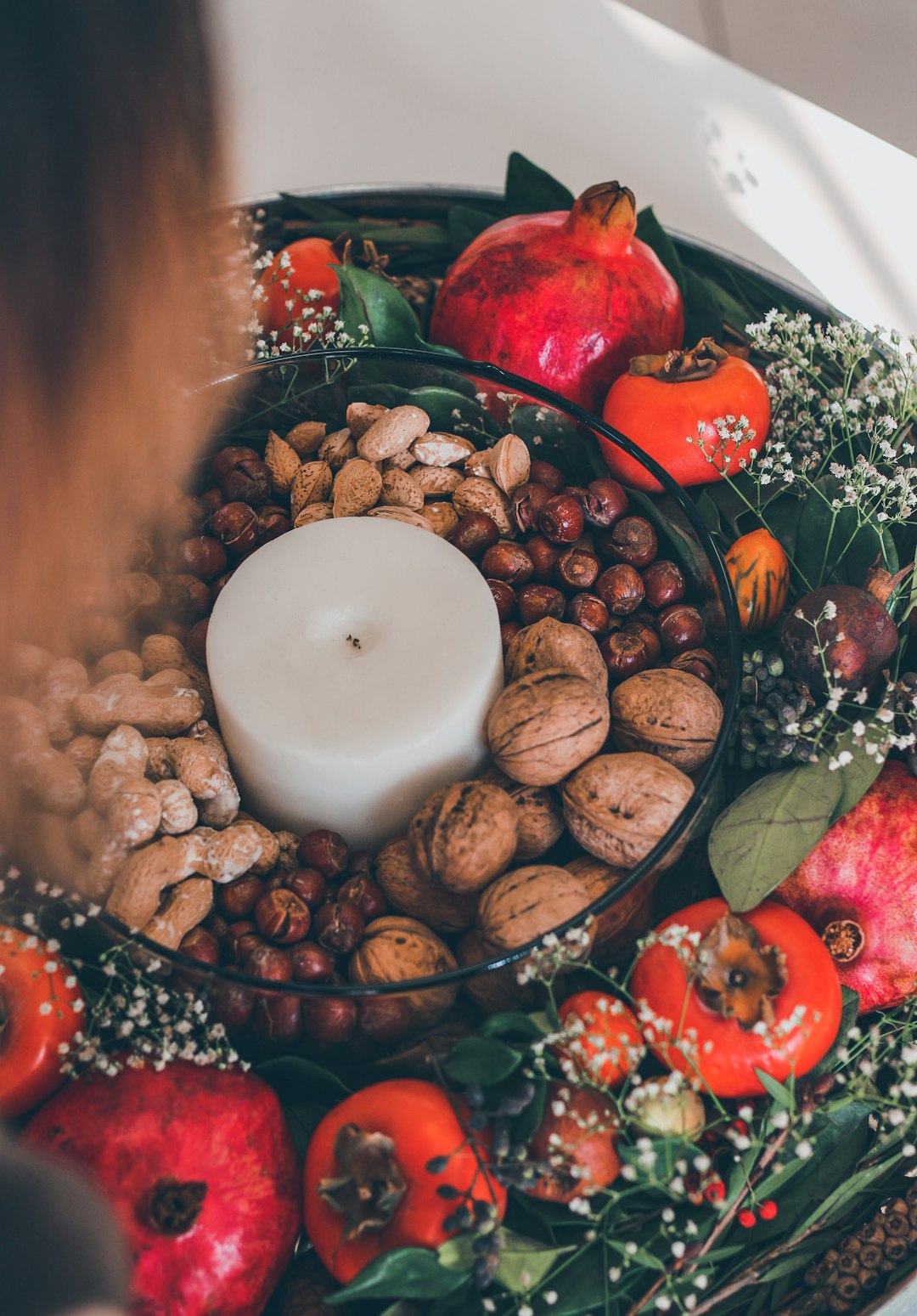 white pillar candle on red and green fruit