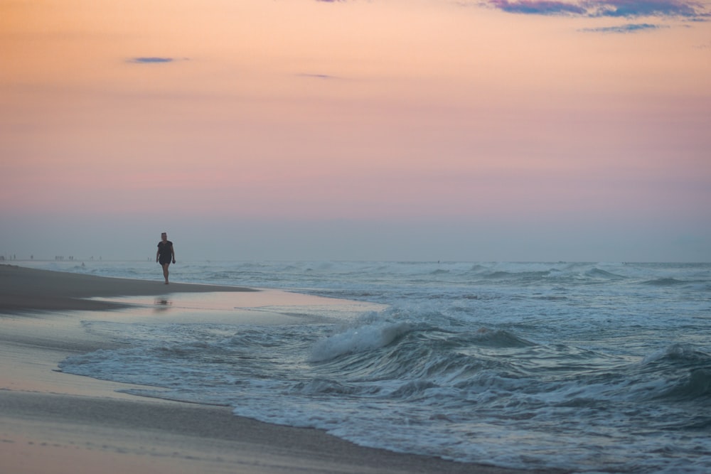 person walking on beach during daytime