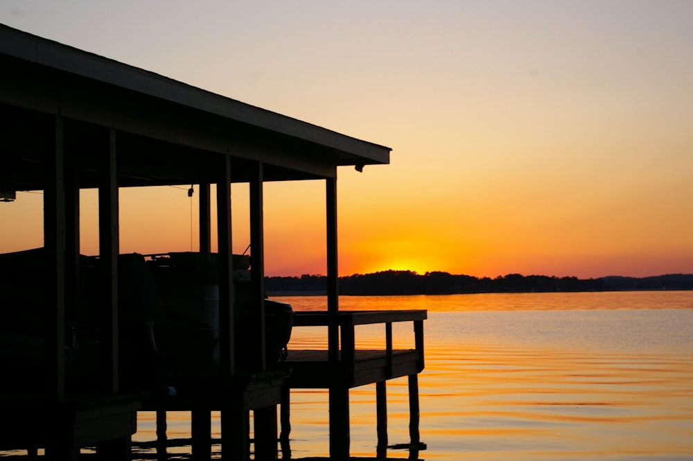 brown wooden dock on sea during sunset