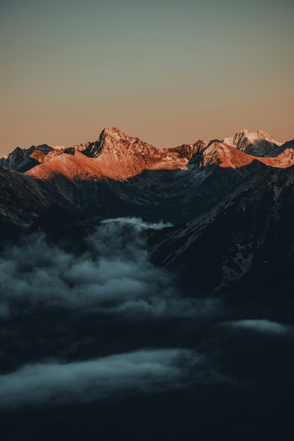 Montagnes brunes et noires sous des nuages gris