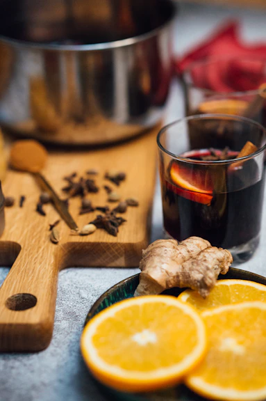 Artisan carefully mixing fresh cinnamon and ginger in a rustic kitchen setting.