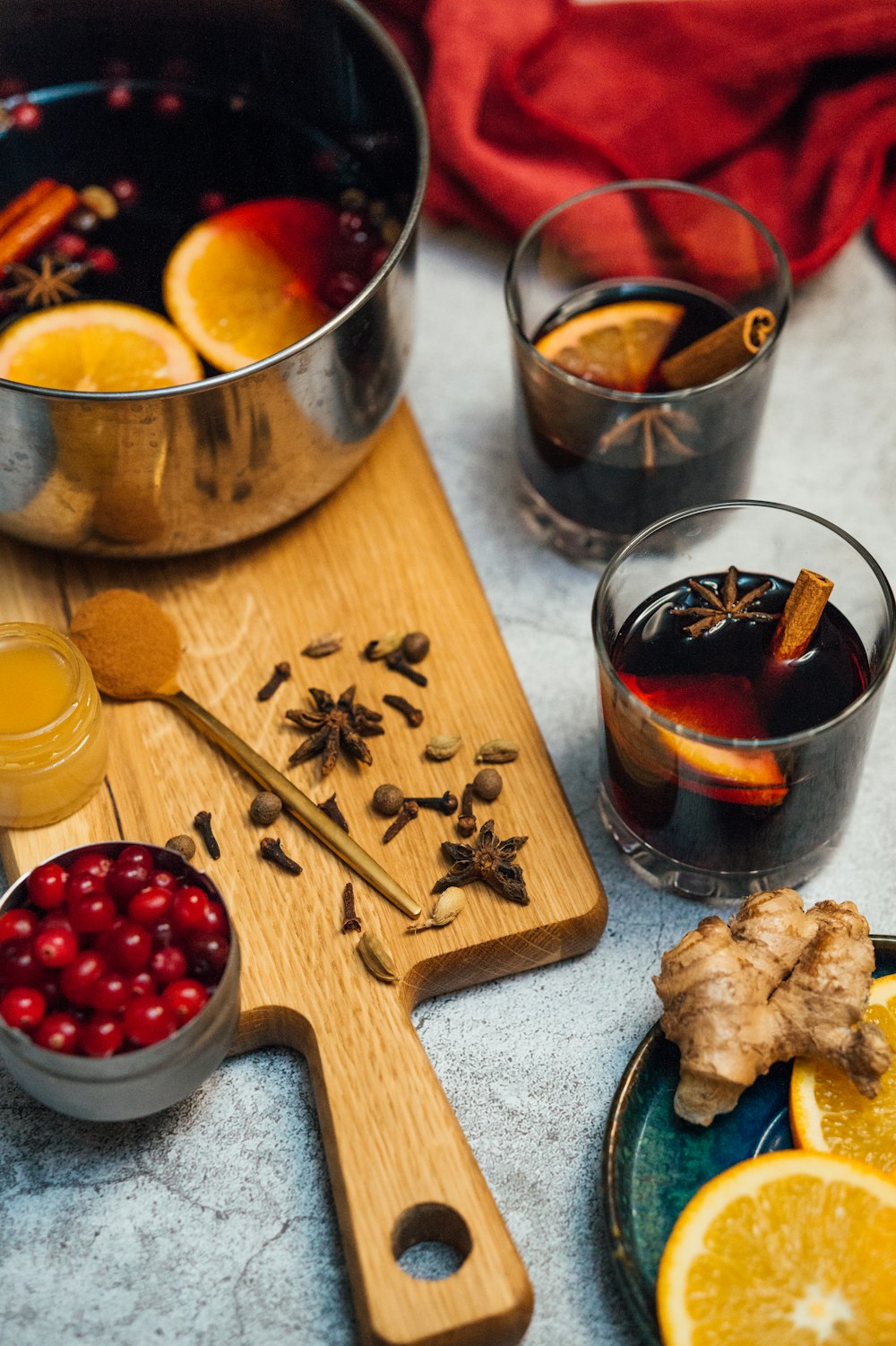 brown wooden chopping board with red and yellow liquid in stainless steel cups