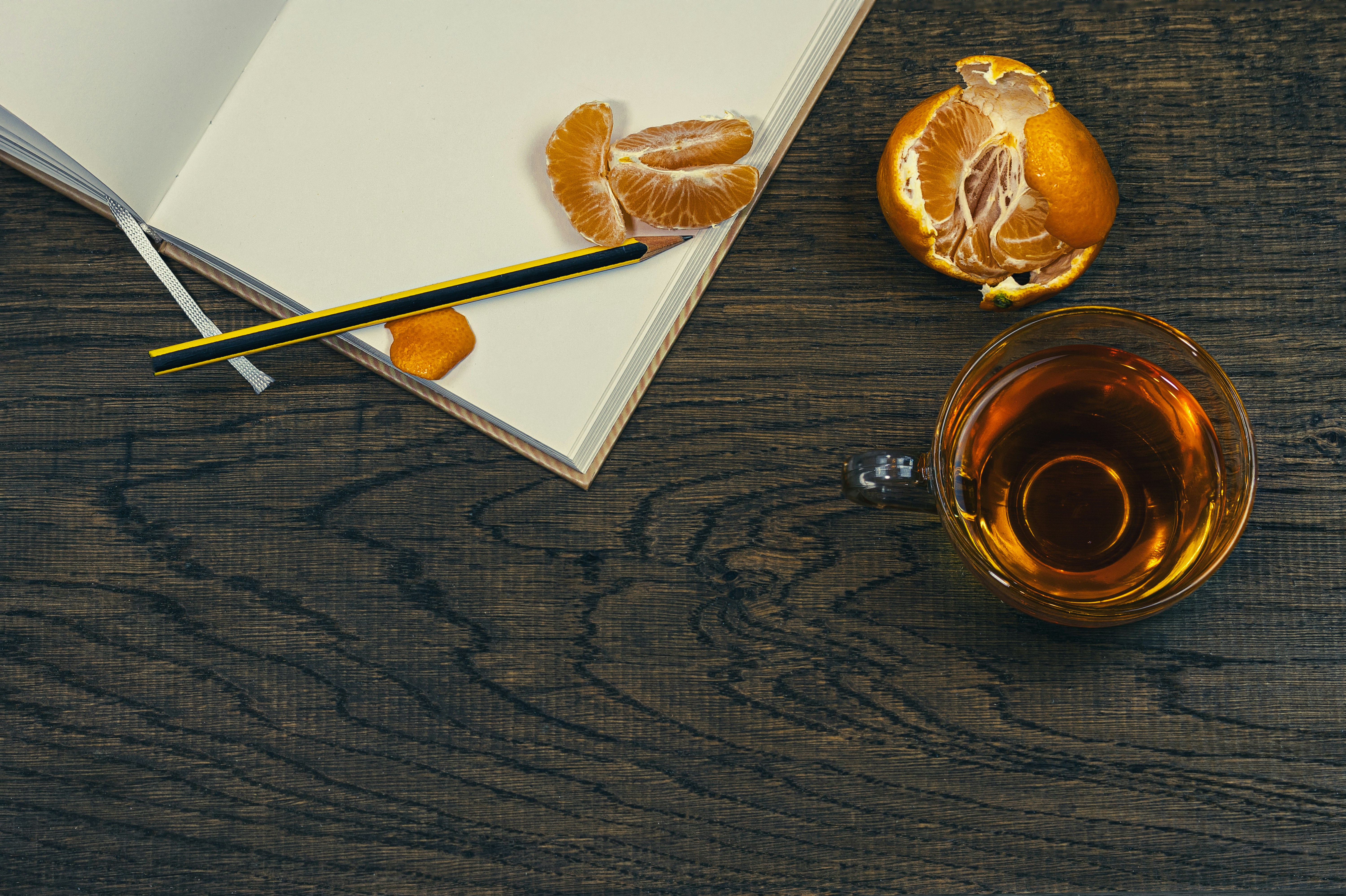 clear glass mug with brown liquid on brown wooden table