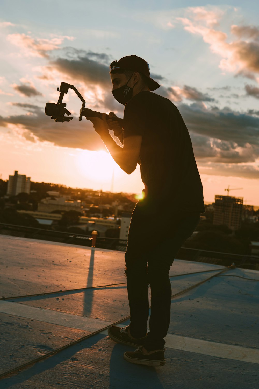 man in black jacket holding black camera during sunset