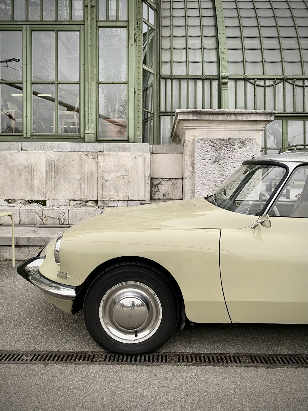 yellow car parked beside brown concrete building