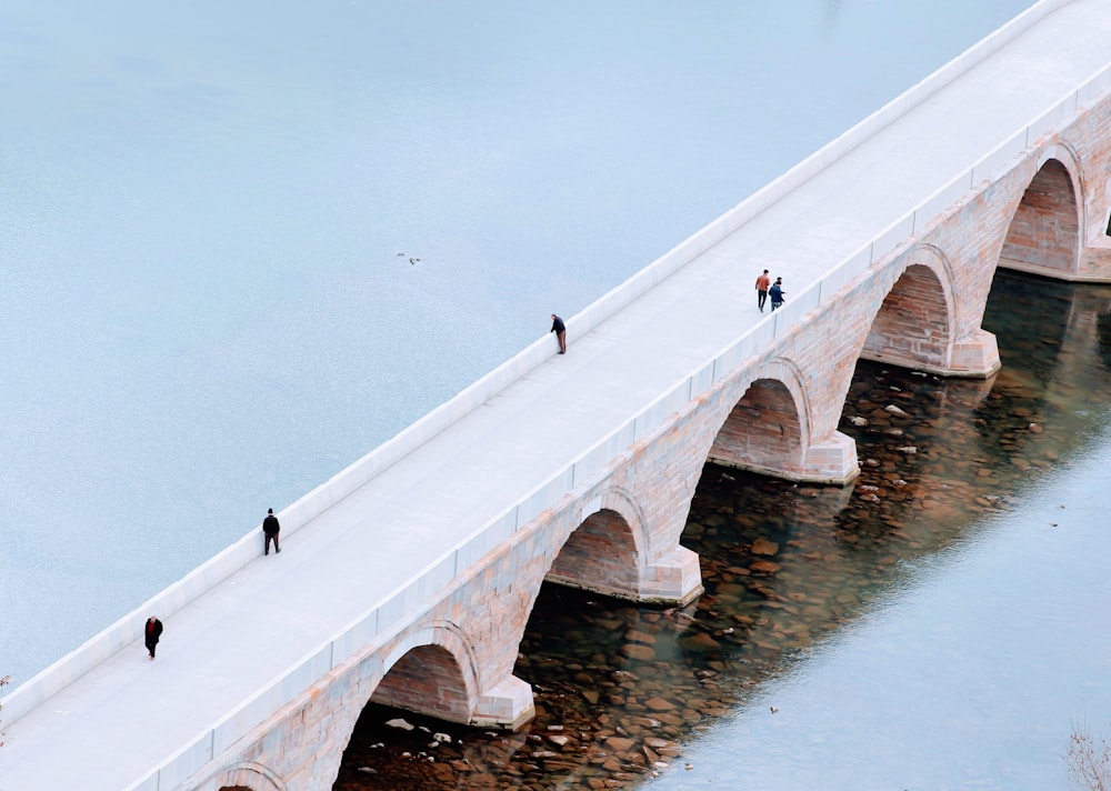 people walking on white concrete bridge during daytime