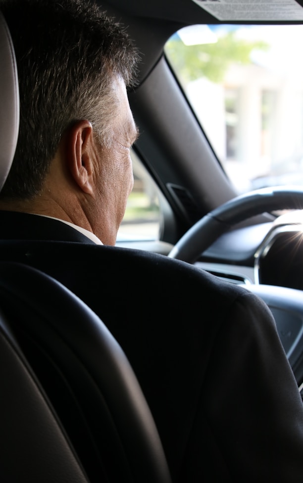 man in black shirt driving car