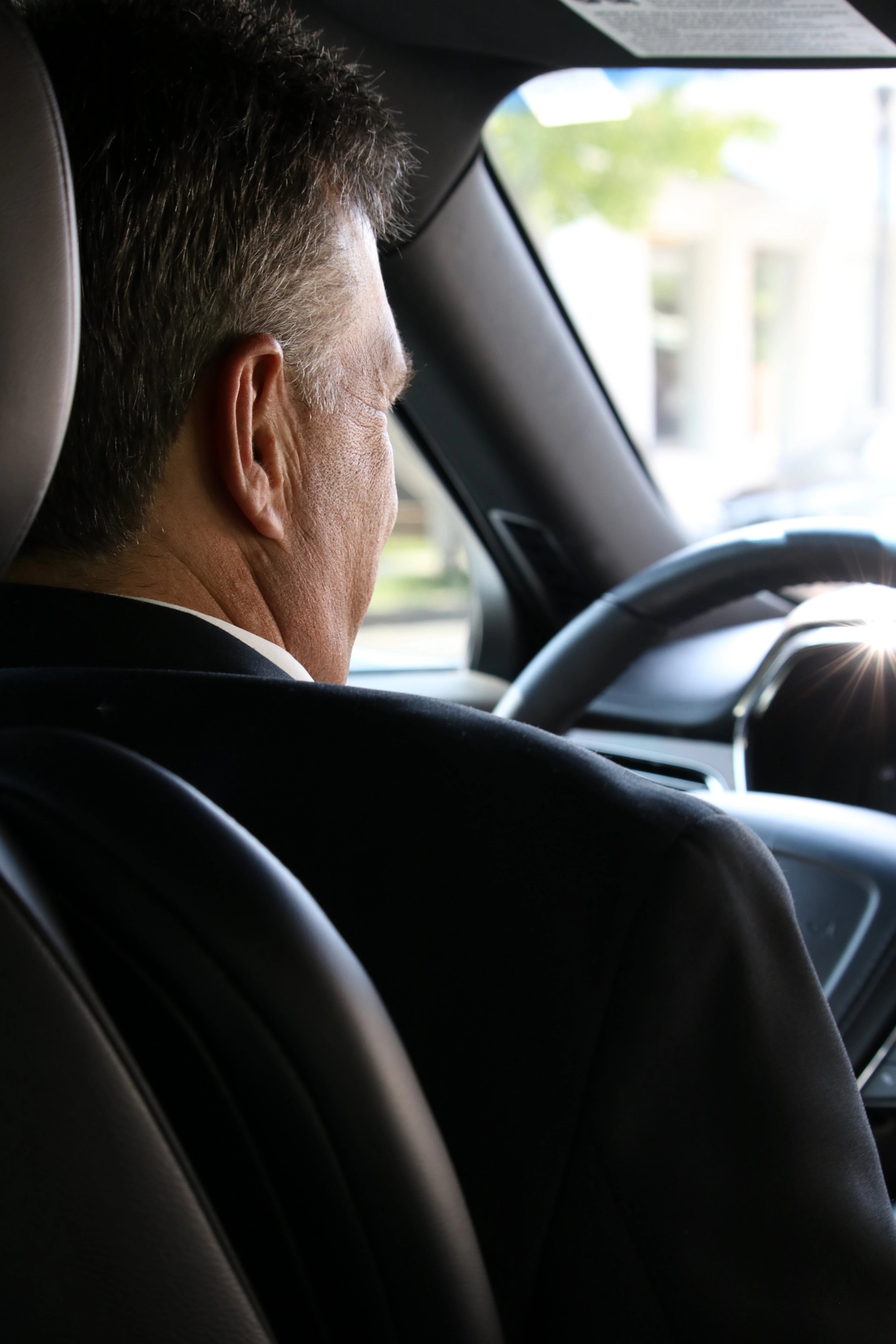 Chauffeur in a suit at the wheel of an executive car