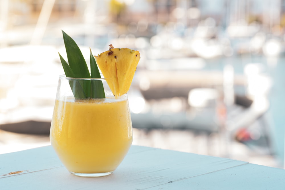 yellow juice in clear drinking glass