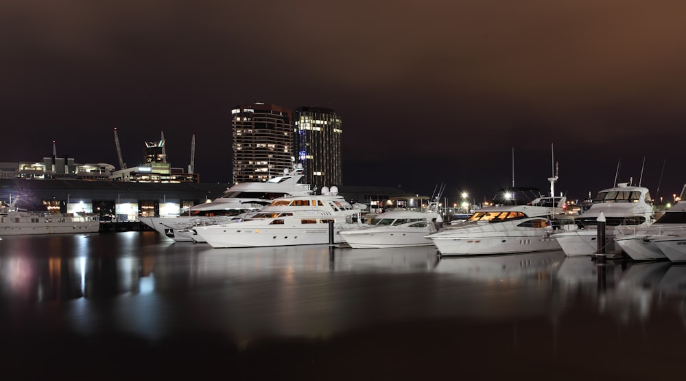 Barco blanco y negro en el muelle durante la noche