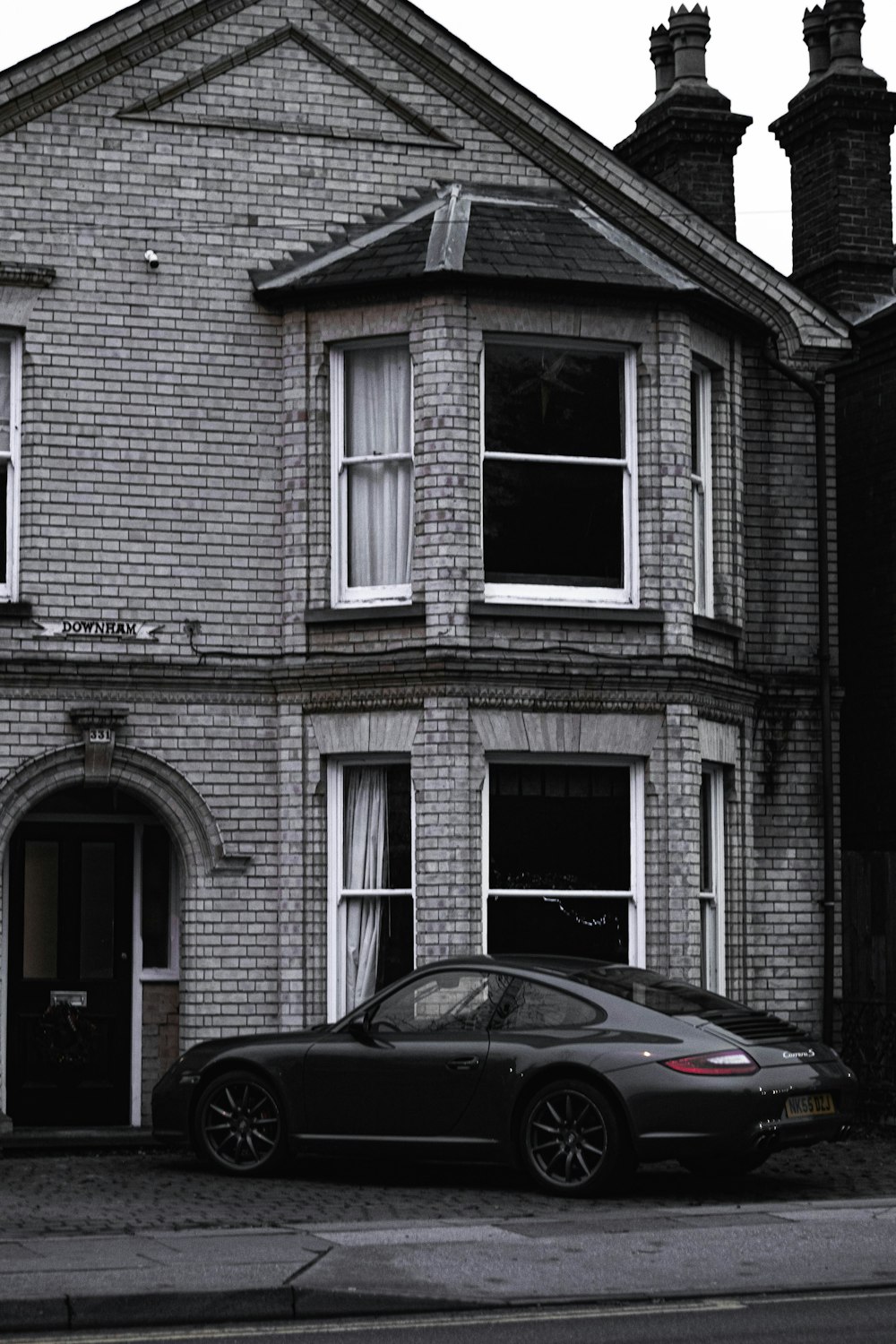 black car parked in front of white and gray concrete building