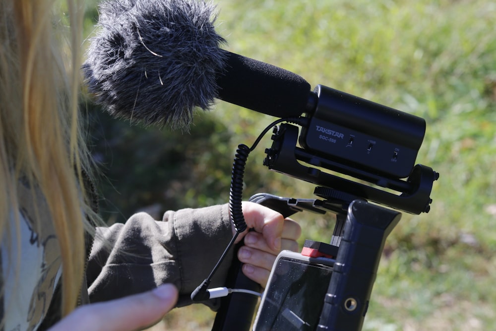 woman in black jacket holding black camera