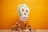 A colorful skull-shaped piñata hangs against an orange backdrop. Below it is a wooden surface with various small liquor bottles, roses, and candy scattered around. The piñata has bright green, orange, and red details, with a prominent toothy grin. The scene evokes a festive and lively atmosphere.