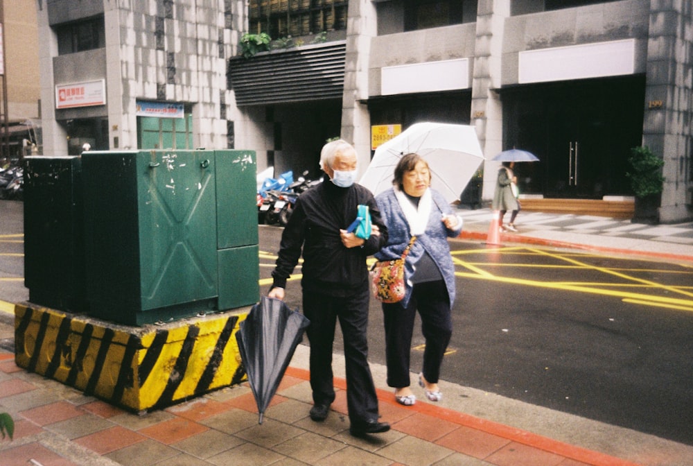 man in blue jacket and black pants standing beside woman in yellow and black jacket