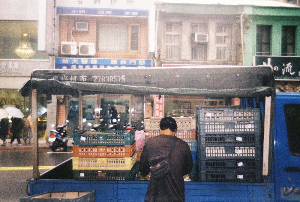 man in brown jacket standing in front of store