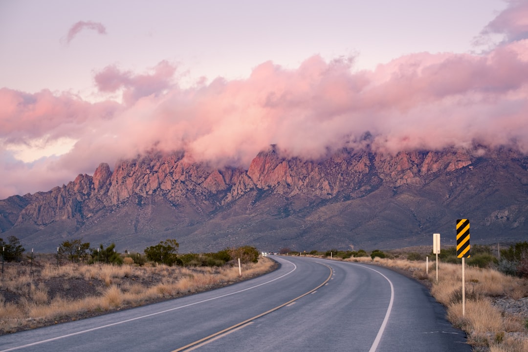 gray concrete road near brown mountain during daytime