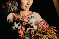 A soft-focus image of a woman smiling, holding a priomii bundle close to her heart.