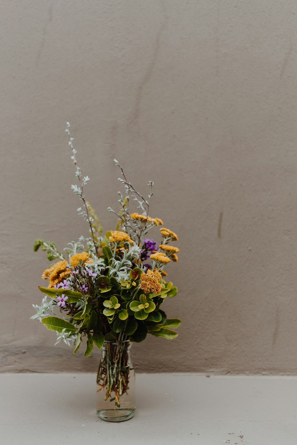 a vase filled with lots of different colored flowers