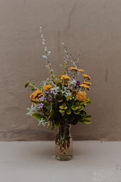 yellow and purple flowers on brown wooden vase