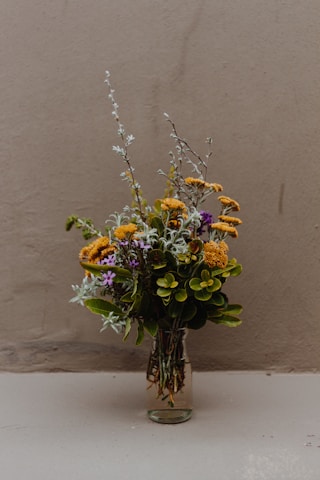 yellow and purple flowers on brown wooden vase
