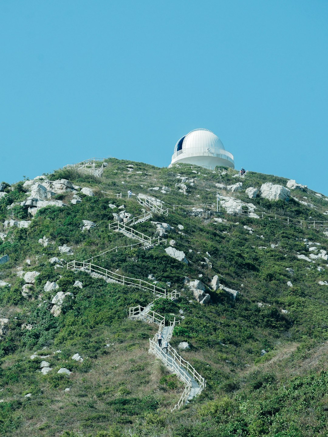 white dome building on top of green mountain during daytime
