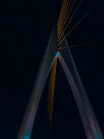 Night view of a bridge with illuminated metallic arches showcasing structural elegance.