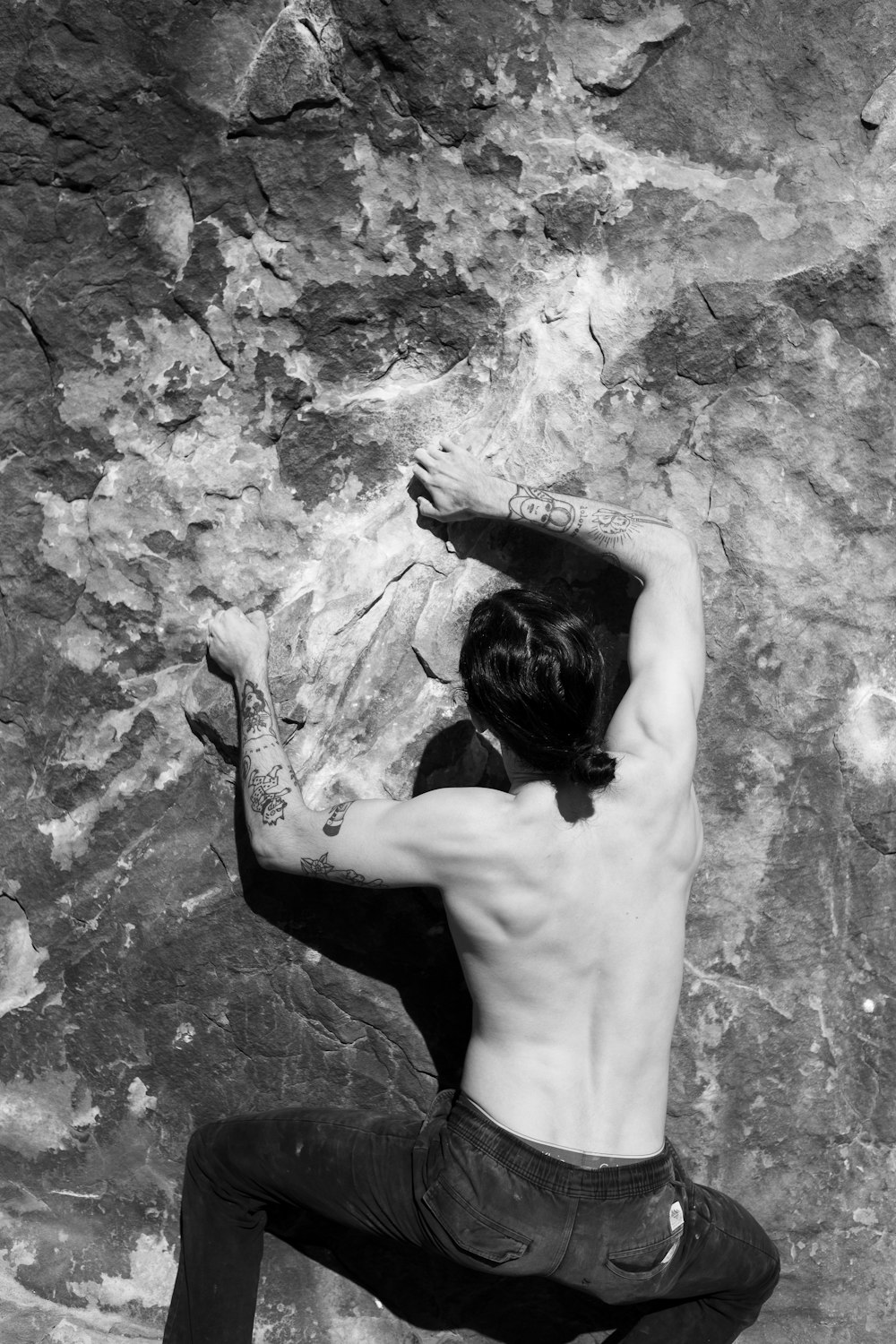 foto in scala di grigi di uomo in topless in pantaloncini