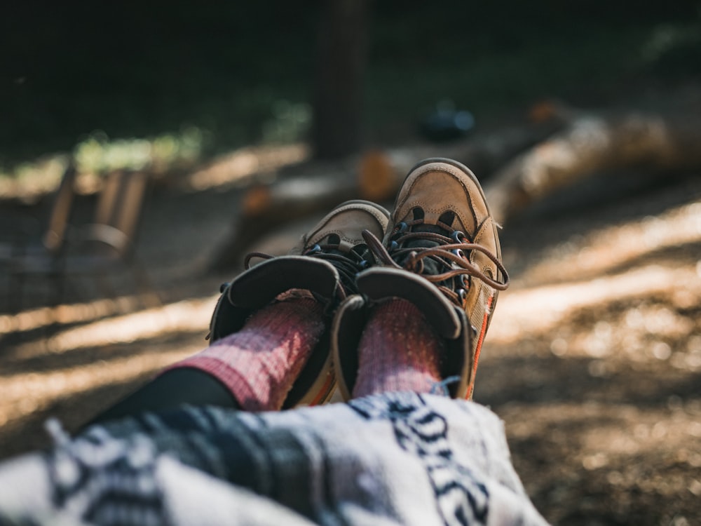 persona che indossa scarpe marroni e nere