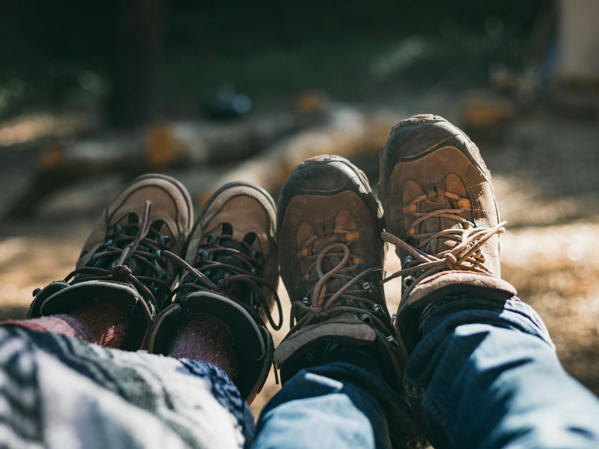 Pies con botas de montaña descansando durante una parada en una ruta a pie