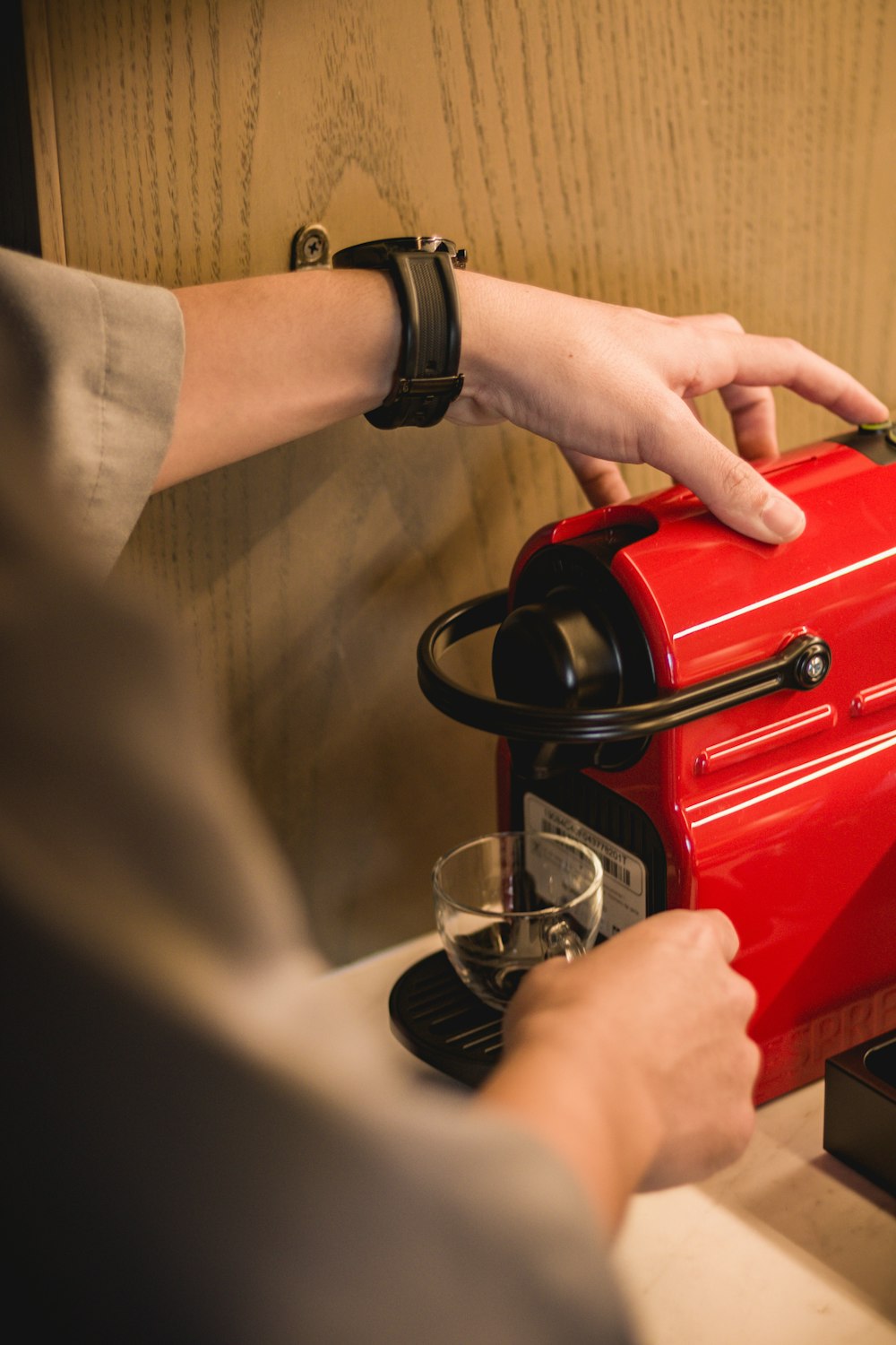 person holding red coffee maker