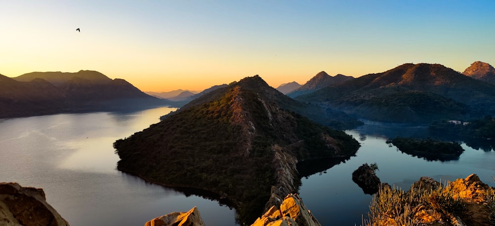 Montaña marrón al lado del cuerpo de agua durante el día