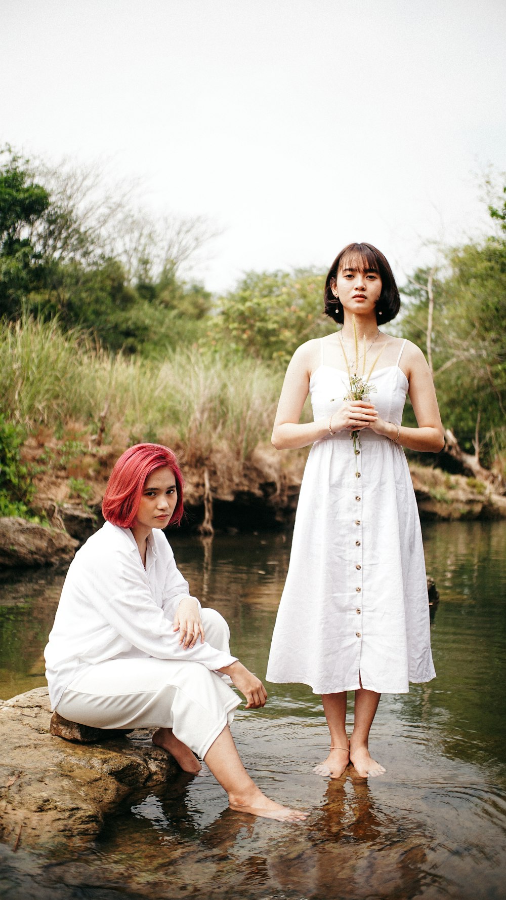 woman in white dress standing near river during daytime