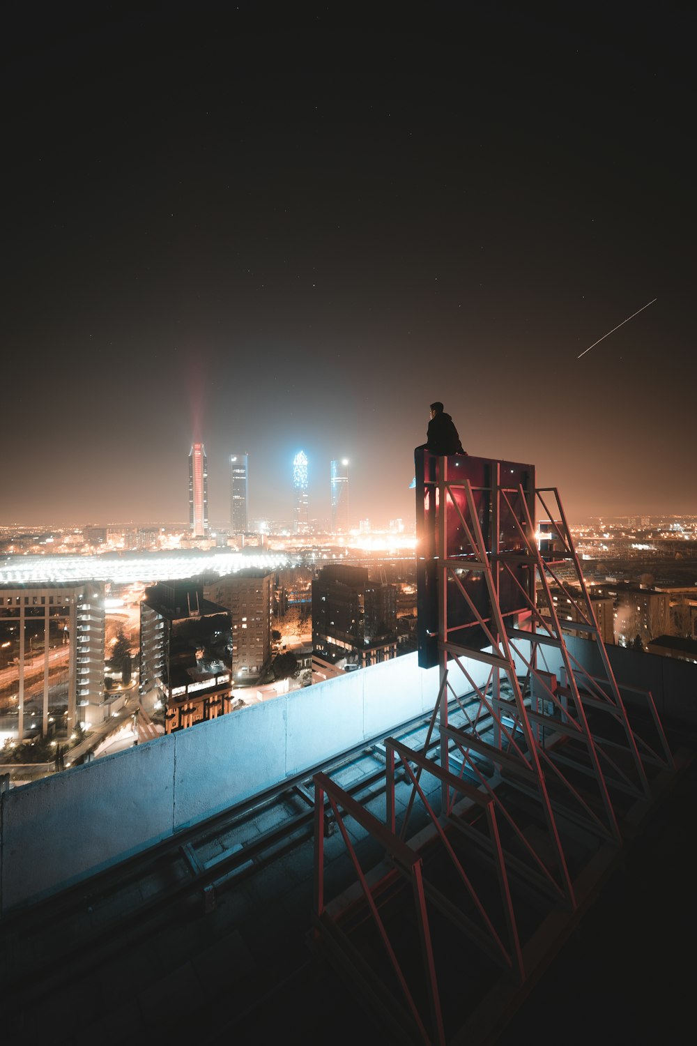 silhouette of man standing on top of building during night time