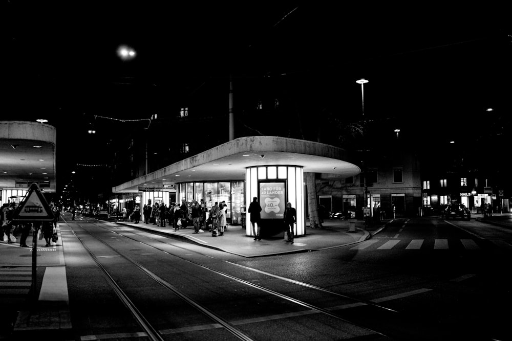 grayscale photo of people walking on sidewalk