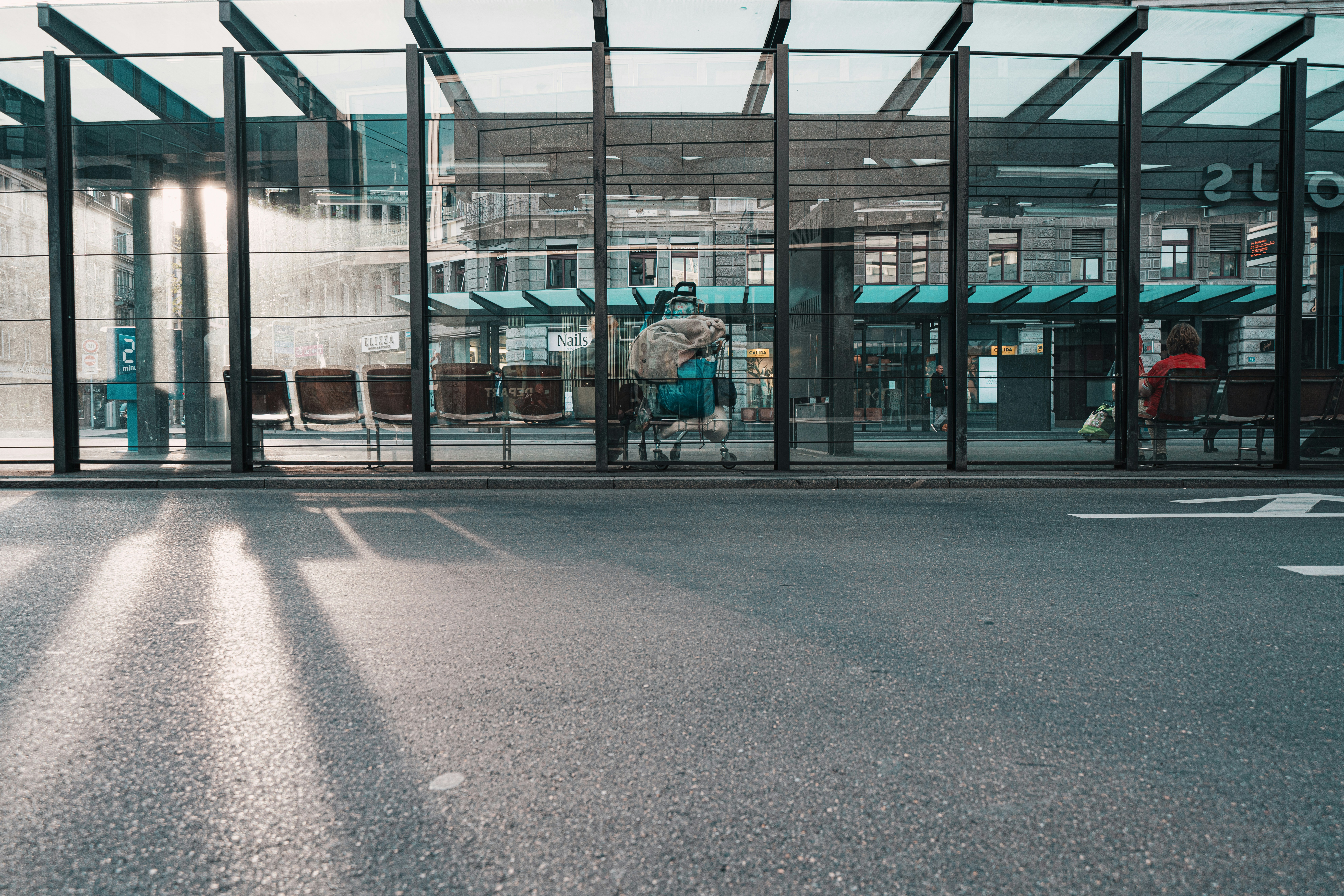 people sitting on bench near glass building during daytime, 