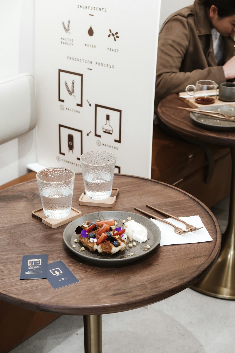 clear drinking glass beside blue ceramic plate on brown wooden table