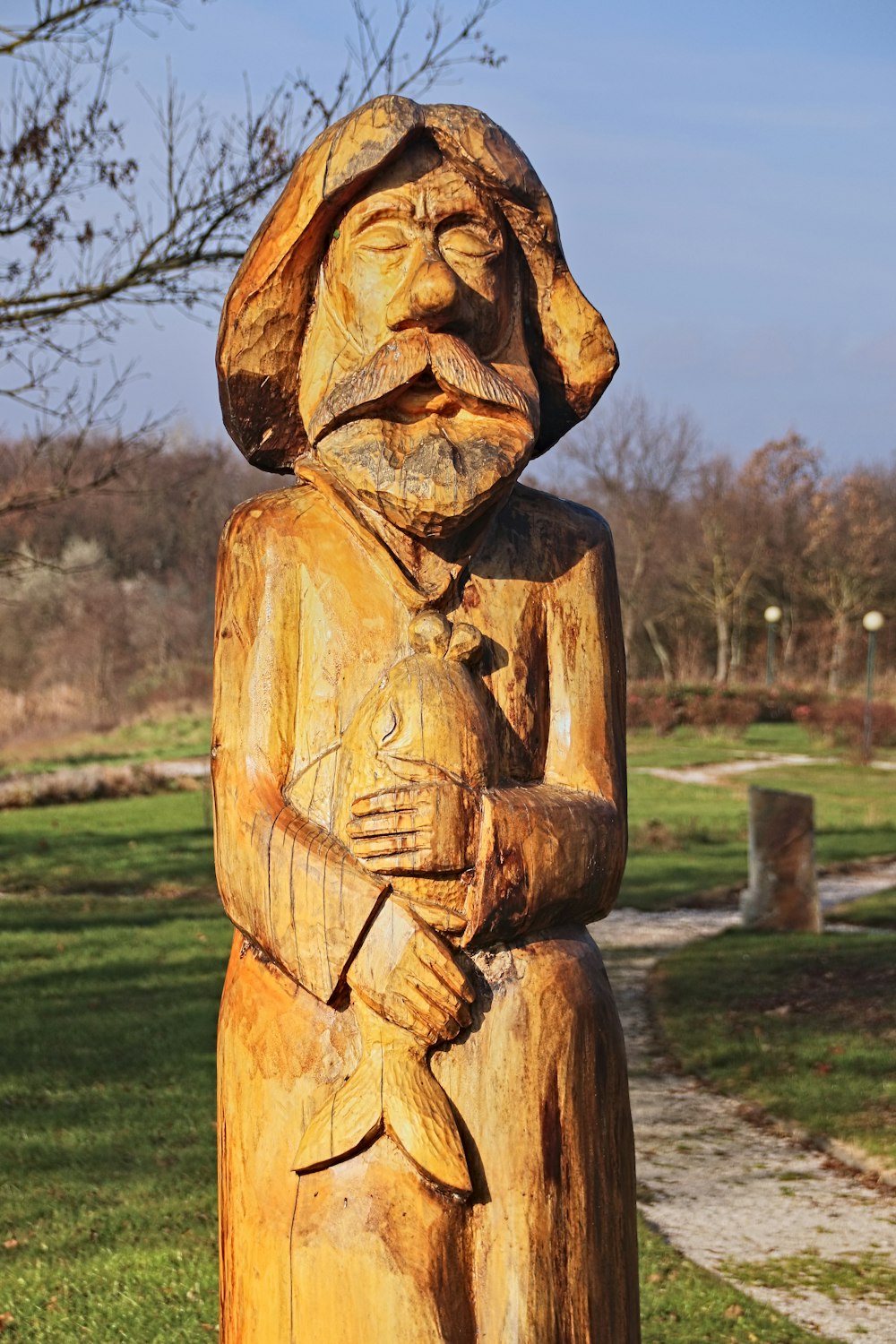 statue en bois brun sur le champ d’herbe verte pendant la journée