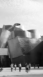 Foto en blanco y negro del Museo Guggenheim de Bilbao, destacando su arquitectura moderna.