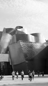 Foto en blanco y negro del Museo Guggenheim de Bilbao, destacando su arquitectura moderna.