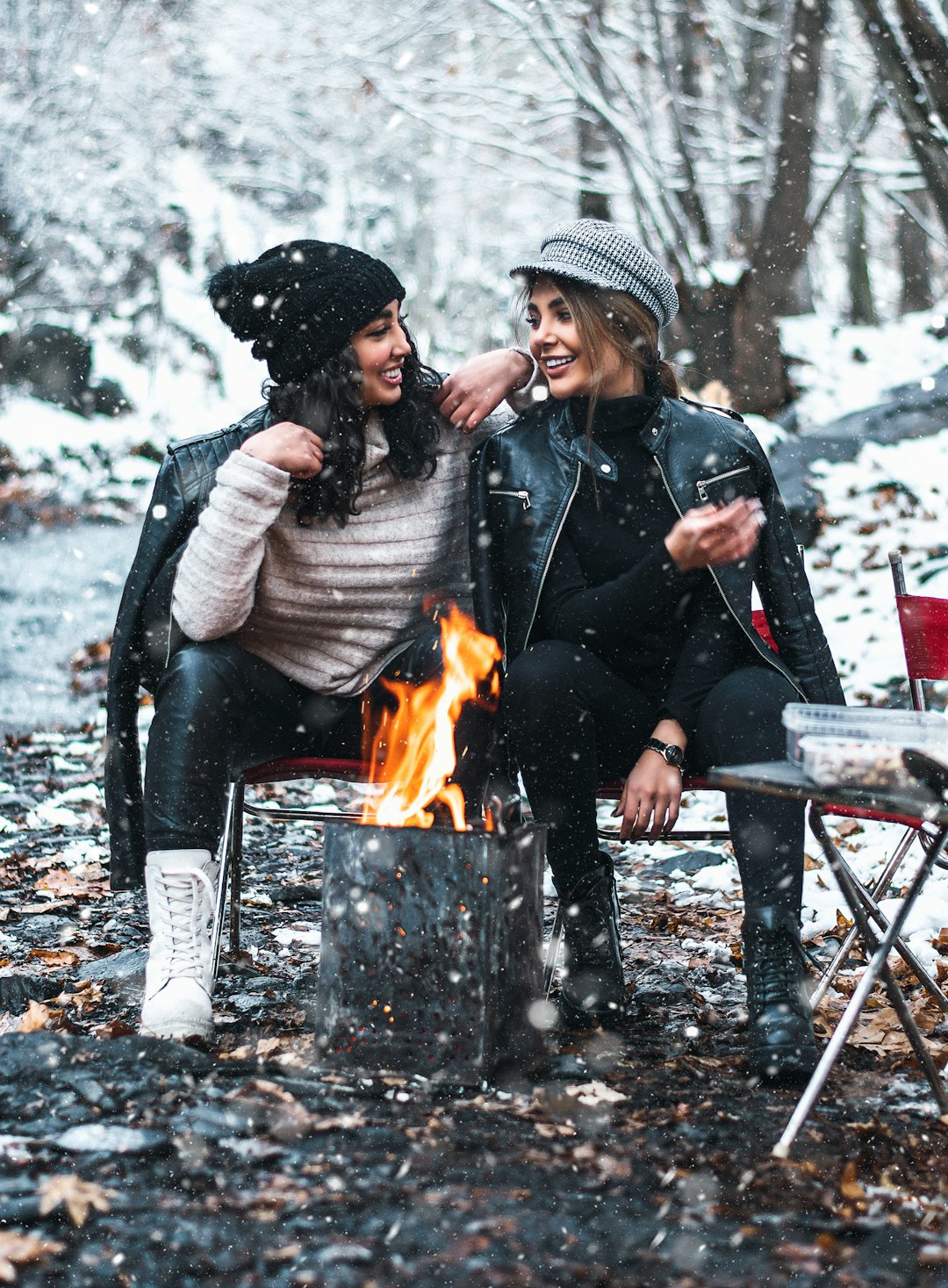 man and woman sitting on chair in front of bonfire