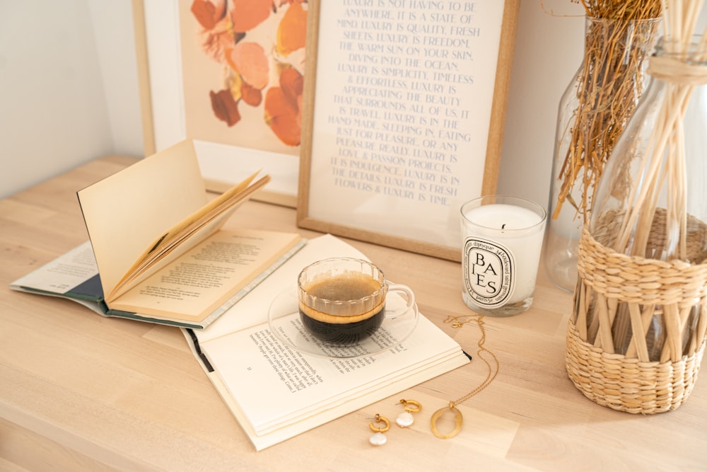 Tasse en céramique blanche à côté d’un livre blanc sur une table en bois marron