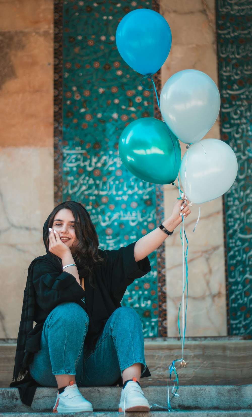 Frau in schwarzem Langarmshirt mit blauen Luftballons