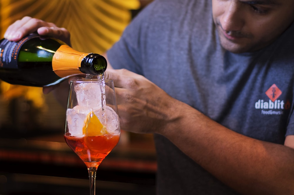 man in gray crew neck t-shirt holding clear wine glass