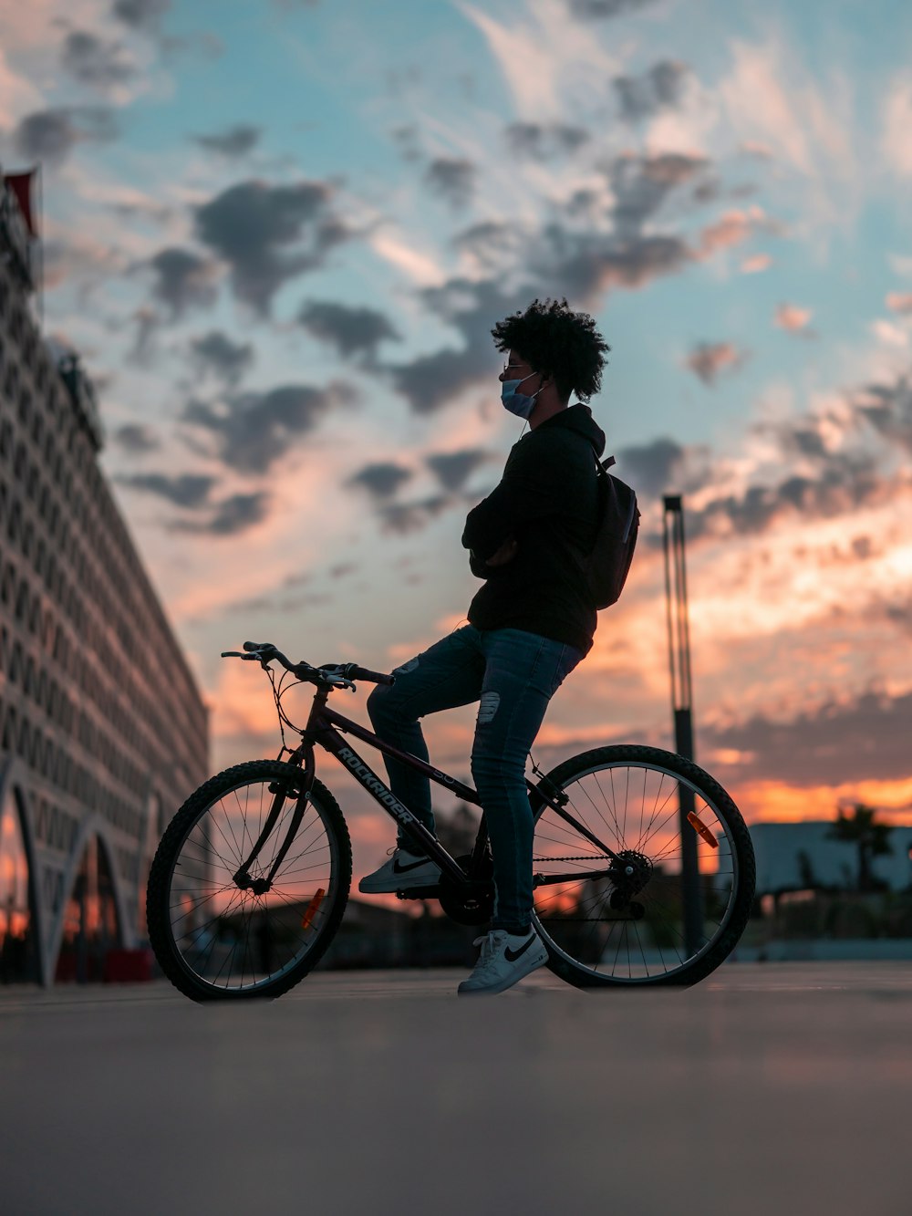 man in black jacket riding on bicycle during daytime